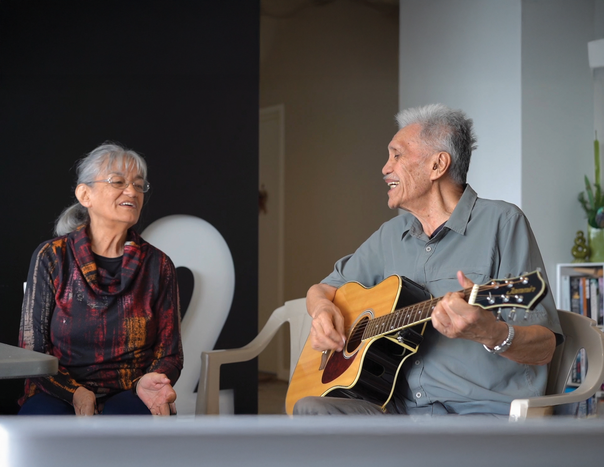 Man and women playing guitar and singing